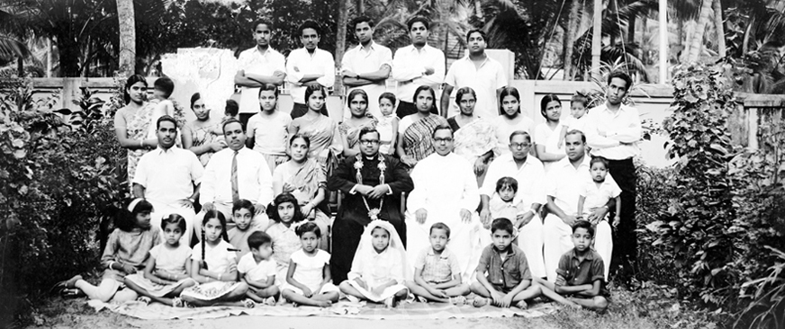 Historical wide group photograph of Fr. Charles M. Fernandez surrounded by family and fellow clergy