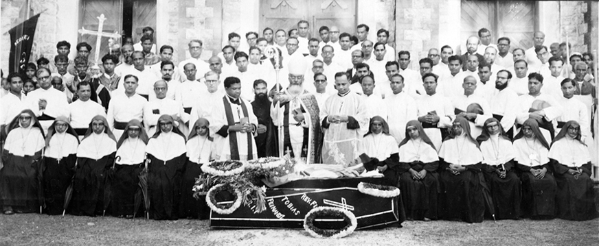Ecclesiastical assembly of Bishops, Priests, and religious sisters around a memorial coffin structure